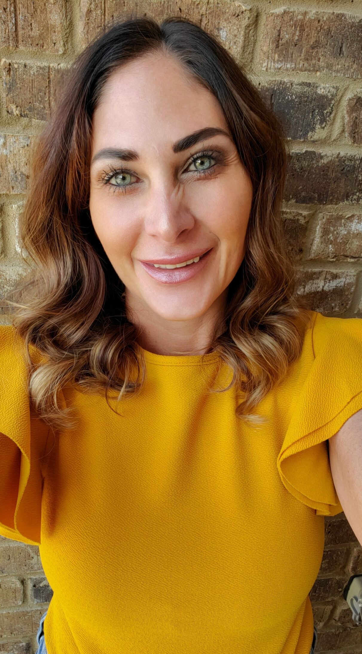 selfie of a woman wearing a yellow top