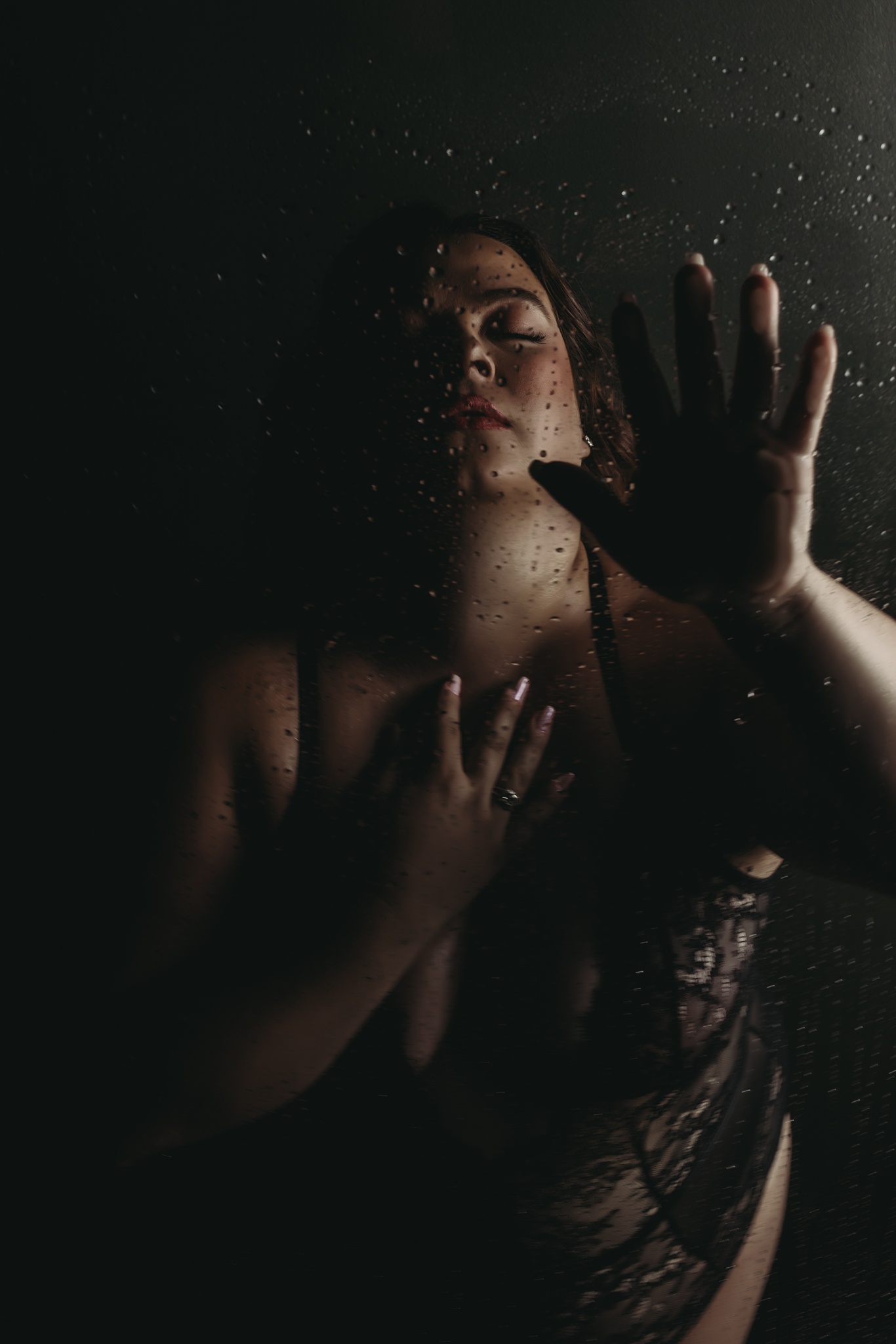 woman in shower with a hand on the glass
