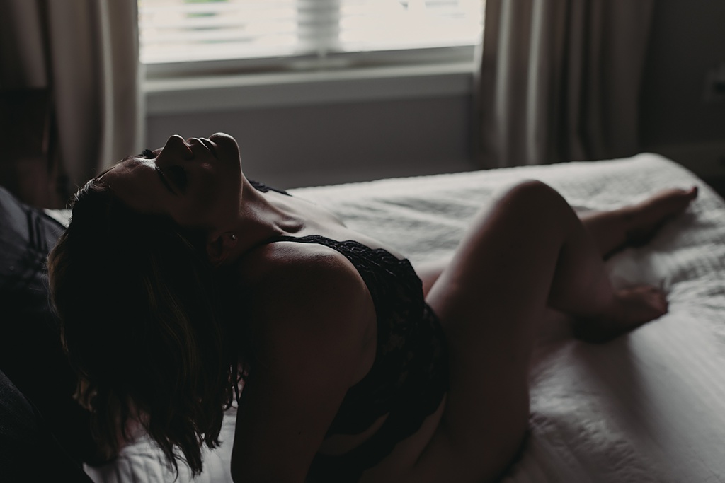 photo of a woman laying in bed for boudoir photos at home